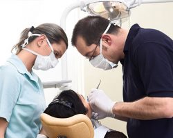 Dentist and Dental Assistant doing an oral surgery | Dental Emergencies | Alluring Smiles in Mesa, AZ - Dr. Javier Portocarrero