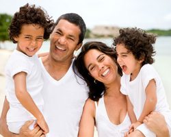 Family wearing all whilte laughing | Family Dentistry | Alluring Smiles in Mesa, AZ - Dr. Javier Portocarrero