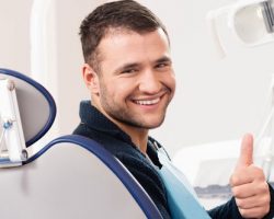 a man giving a thumbs-up after receiving a dental exam